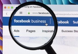 Magnifying glass enlarging Facebook Business logo