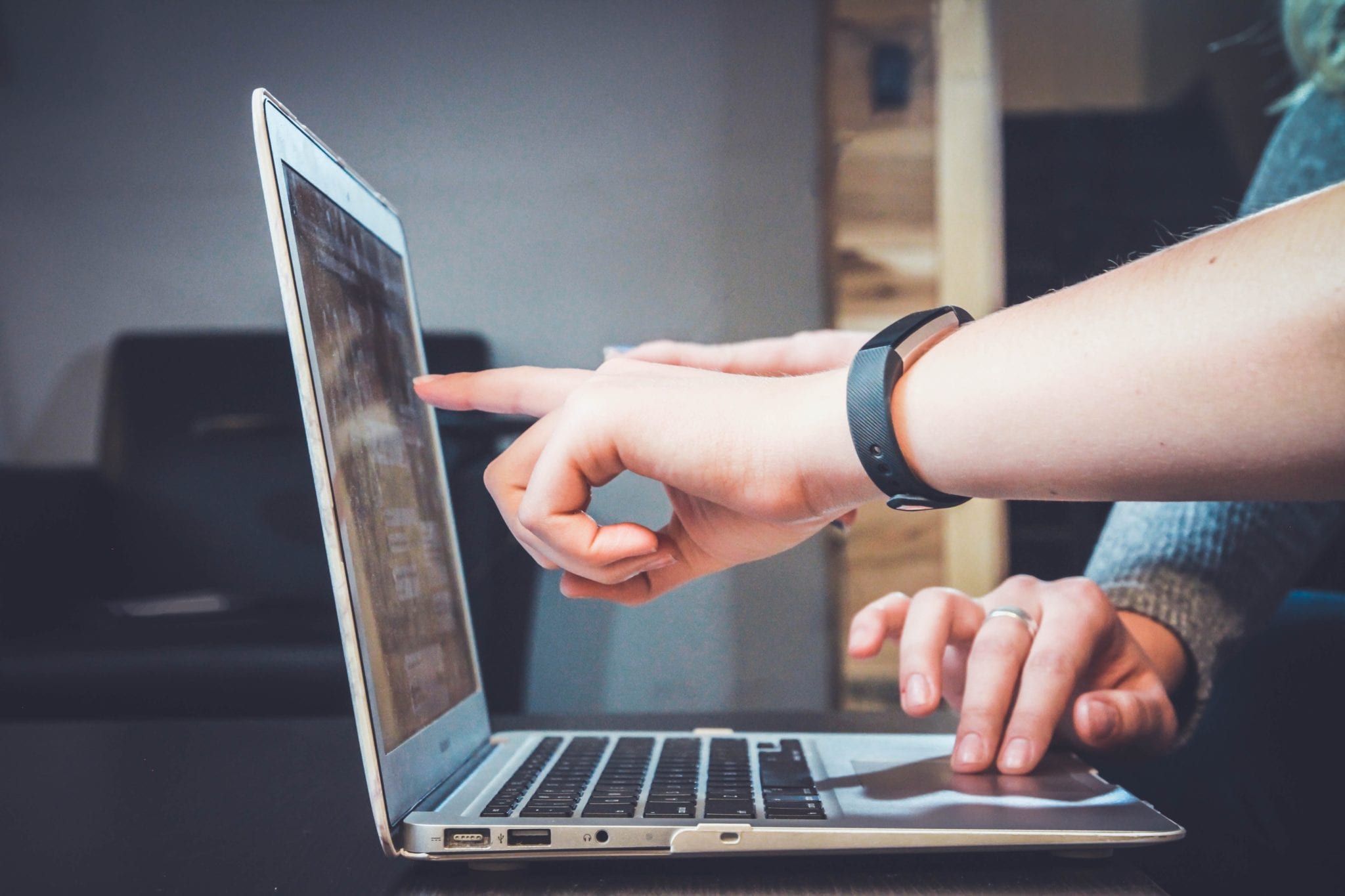 person pointing at computer screen