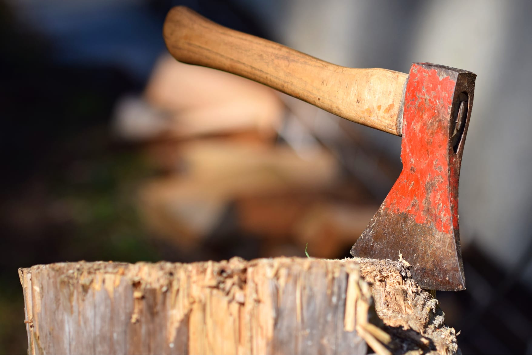 An axe with a red axehead and a wooden handle is stuck in a stump, which is used as a display ad for google ads.