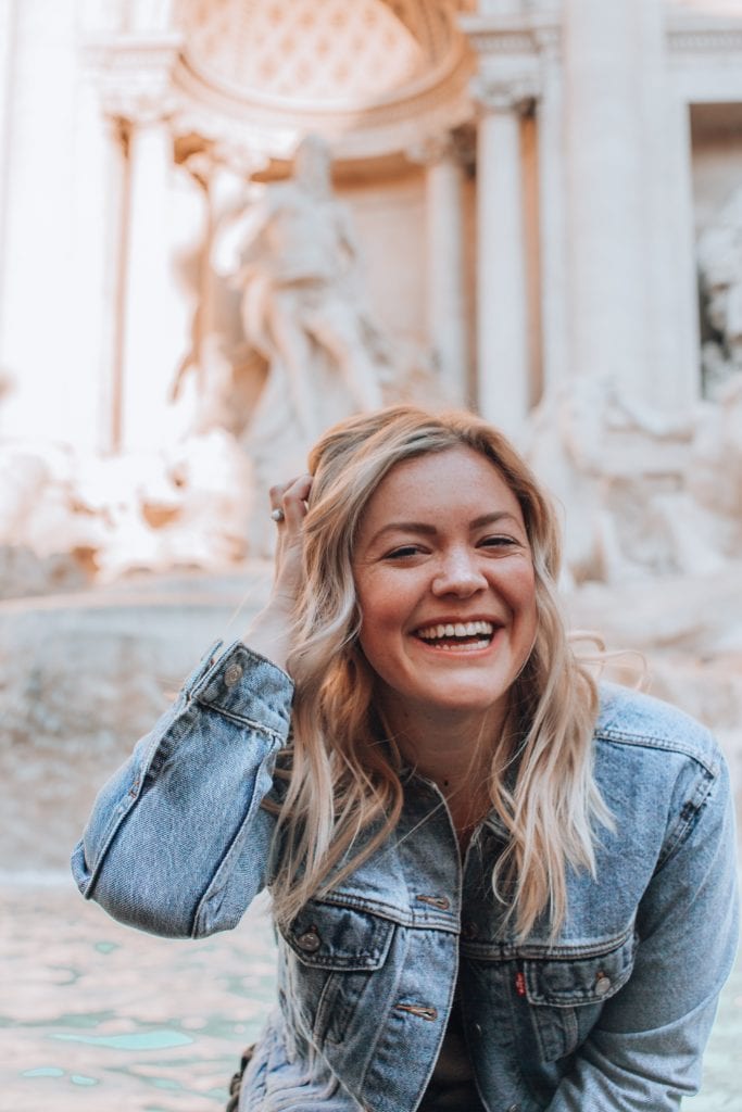 Teenage girl smiling in front of Trevi Fountain