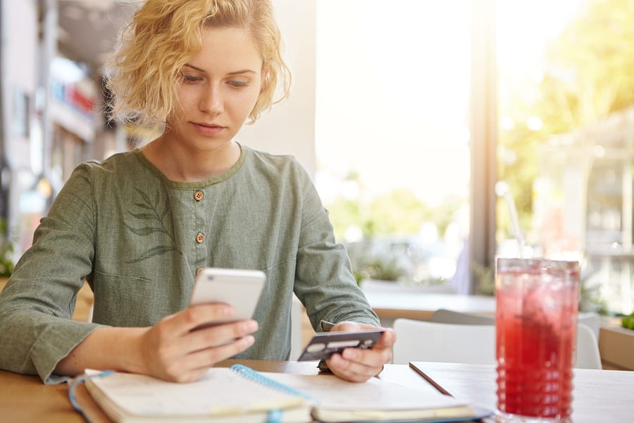 Woman online shopping with credit card on her smartphone