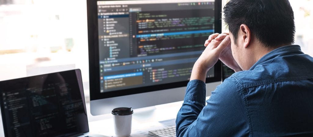 stressed man at computer editing source code on website