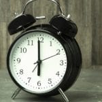 black alarm clock showing time to learn spanish
